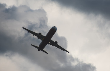 Silhouette of a plane taking off against the blue sky