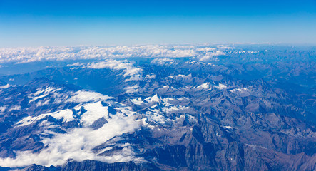 Mountains and blue sky. View out of an airplane window.