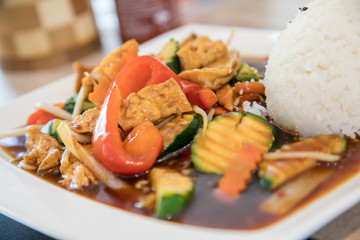 Vegetarisch Tofu Gemüse aus Wok mit pikanter, brauner Szechuan Soße und Reis im Restaurant