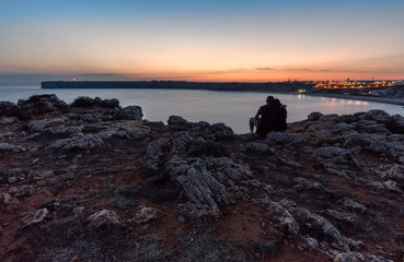 a couple in love over the cliff at sunset romantic concept