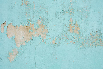 the blue old paint texture is chipping and cracked at the wall