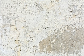 the white old paint texture is chipping and cracked at the wall