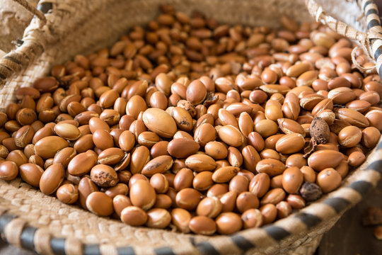 Close up of Argan nuts (Argania spinosa) in a cooperative straw basket in Morocco. Produced only in Morocco, this fruit is widely used in the cosmetics industry.