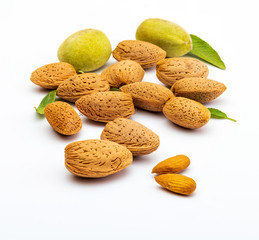 Raw almonds, peeled, with peel, skin (almendrucos) and almond leaves. Isolated on white background.