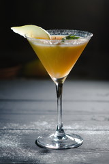 yellow christmas alcohol cocktail with pear on dark background