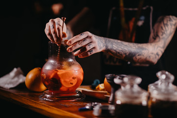 The process of cooking shisha, hookah bowl.Fruit in ice shaking.Citrus fruit for Shisha.Tattooed hands