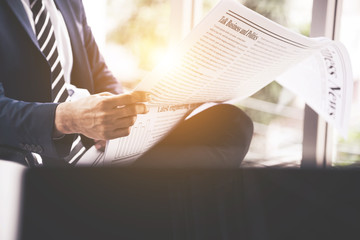 businessman reading newspaper in office