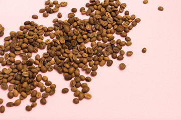 Coffee grains on a gently pink background. Flat lay, top view