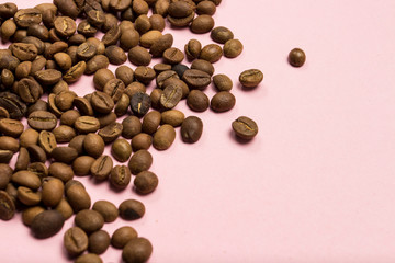 Coffee grains on a gently pink background. Flat lay, top view