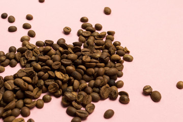 Coffee grains on a gently pink background. Flat lay, top view