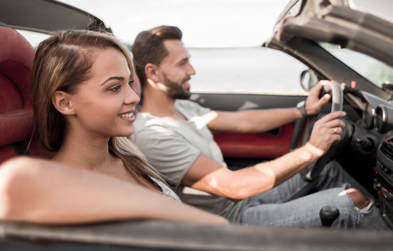 close up.smiling couple sitting in a convertible car