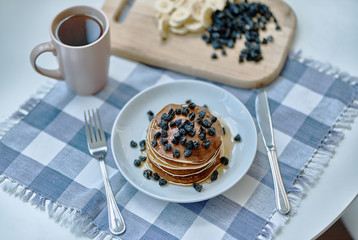 Pancakes poured with honey, syrup and sprinkled with berries.