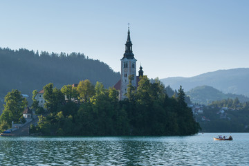 Fototapeta na wymiar Amazing View On Bled Lake, Island,Church And Castle With Mountain Range (Stol, Vrtaca, Begunjscica) In The Background-Bled,Slovenia,Europe