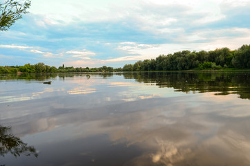 Clouds and trees reflected in the river, landscape