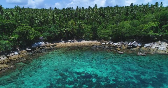 Aerial: Blue lagoon with turquoise water with and palm trees on the beach shore. Racha Island. Thailand.