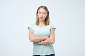 Portrait of beautiful young woman with arms crossed isolated over white background