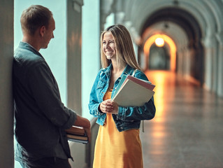The guy and the girl communicate in the university.