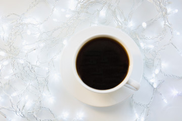 Cup of black coffee on winter white table. Xmas holiday time. Top view.