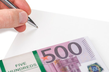 Male hand with a pen on a blank sheet of money with a face value of five hundred euro