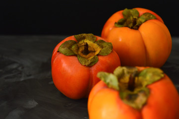 Persimmon fruits on dark background