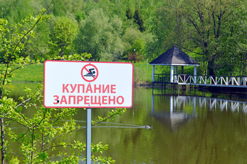 Табличка "Купание запрещено" на фоне водоема