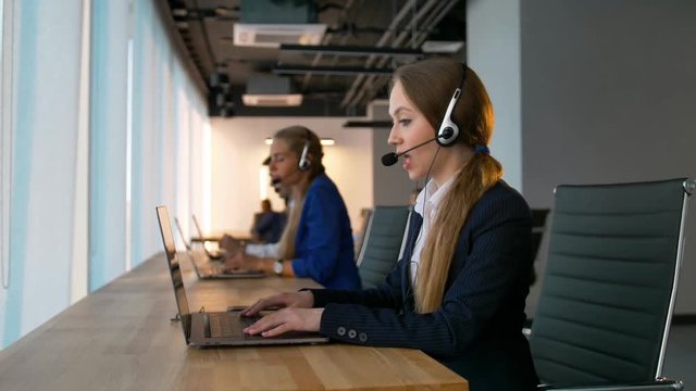Pretty confident call-center female consultant have deal with customers. Pleasant conversation with the client and solving problems with an important customer. Middle shot and slider camera movement.
