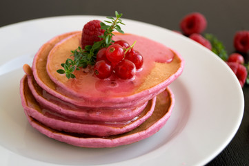 Berry homemade pancakes on a black background.