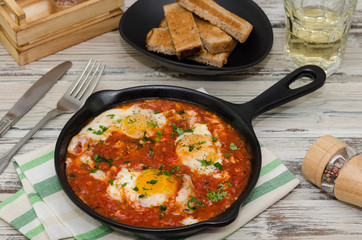Homemade breakfast shakshuka of fried eggs with tomatoes. Shakshuka. Eggs in tomato sauce for breakfast.Top view.
