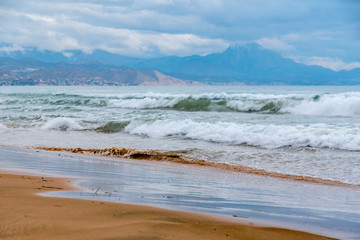 Olas del mar sobre la arena de la playa en la costa del Mediterráneo una mañana de verano con olas suaves rompiendo en la orilla