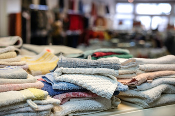 Stapel gebrauchter Textilien in einem Second Hand Laden - selektive Schärfe