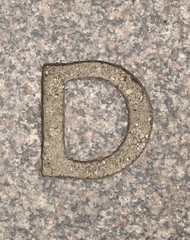 Letter D. On stone background