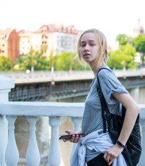 Naklejka na ściany i meble Young tourist girl on a bridge in a European city.