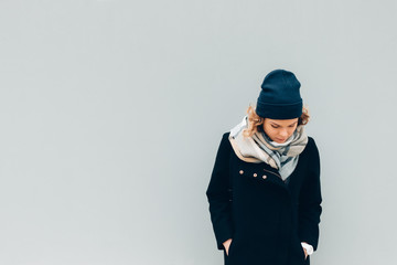 Female wearing coat, beanie hat and scarf