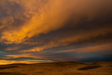Fototapeta na wymiar Sunset clouds over prairie field