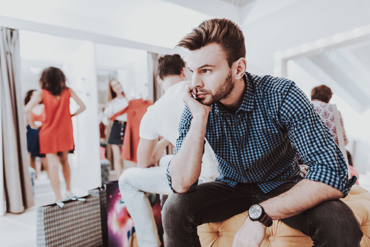 Young Man Waiting For Girlfriend In Dressing Room.