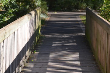 small wooden bridge from first person perspective as part of a path, walkway, trail, track