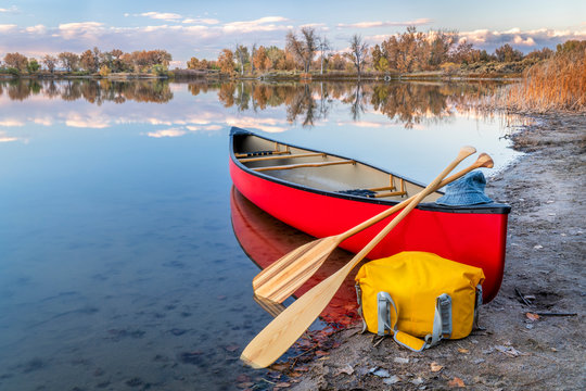 red canoe on a lake shore