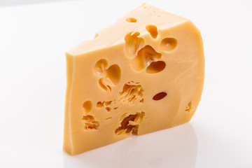 Piece and slices of cheese on a white background