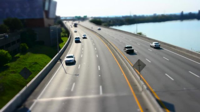 Tilt Shift footage of traffic on Interstate 64 in Louisville, KY, River on right side of road, shot from overpass