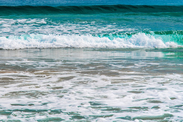 Olas del mar sobre la arena de la playa en la costa del Mediterráneo una mañana de verano con olas suaves rompiendo en la orilla