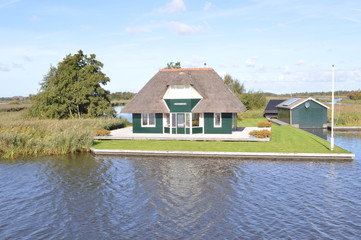 Fototapeta na wymiar een vakantiewoning met rieten dak in het natuurgebied De Alde Feanen in Friesland