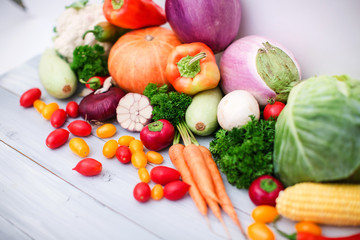 Heap of fresh vegetables on wooden background.