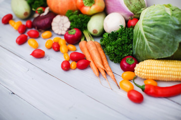 Heap of fresh vegetables on wooden background.
