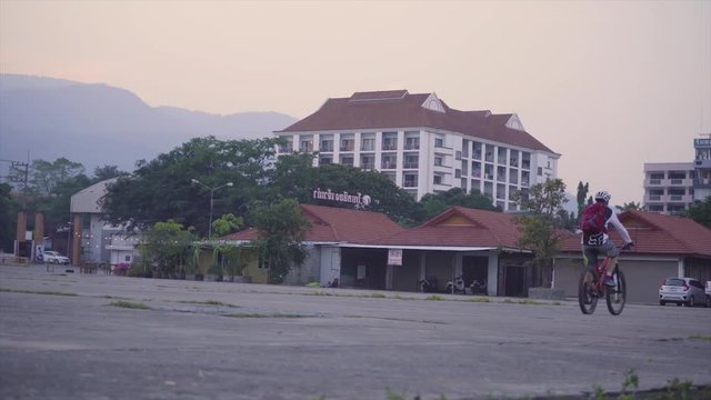 Man is doing wheelie on a bicycle.