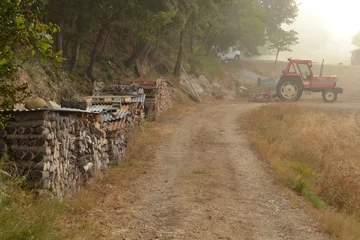 Fototapeten landbouwtractor en werktuigen en hakhout bij een boerderij in de Provence op een mistige morgen © henkbouwers