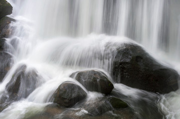 Closeup of a Waterfall Cascading Over Rocks. Flowing water from a waterfall in Whatcom Falls Park,...