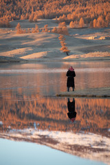 Mongolia Altai lake in autumn at sunrise - tree reflexion with fisherman