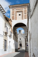 Fototapeta na wymiar Callejón con arco/ callejón con arco e iglesia al fondo en la Puebla de Montalban, provincia de Toledo. Castilla-La mancha. España.