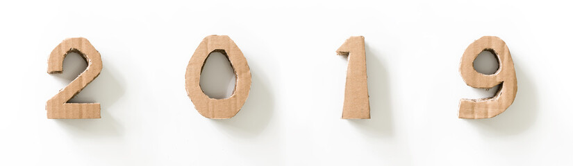 2019, handmade 3D numbers made of reused cardboard paper, on white background.