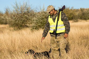 Naklejka na ściany i meble Hunters with a german drathaar and spaniel, pigeon hunting with dogs in reflective vests